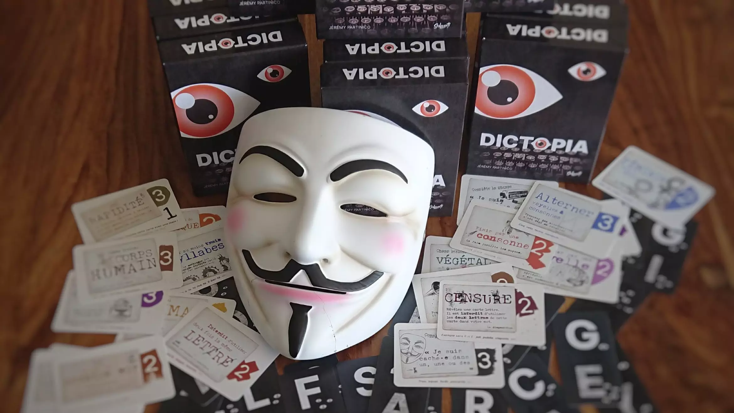 Masque de Guy Fawkes devant des jeux Dictopia